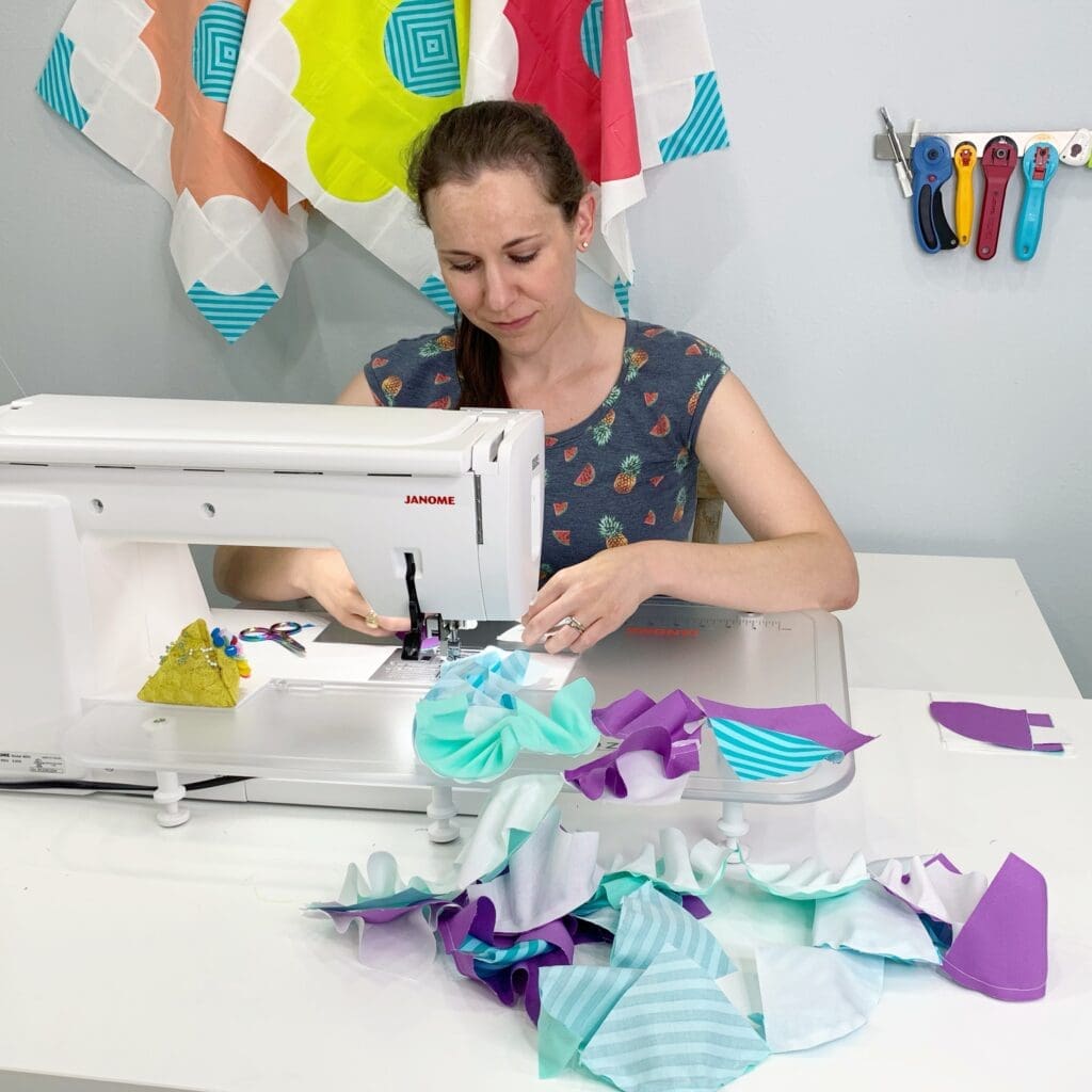 Woman sewing colorful fabric pieces at machine