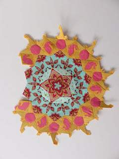 Turquoise and yellow fabric mandala with pink accents