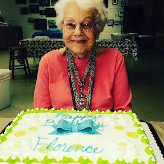 Smiling elderly woman with decorated birthday cake