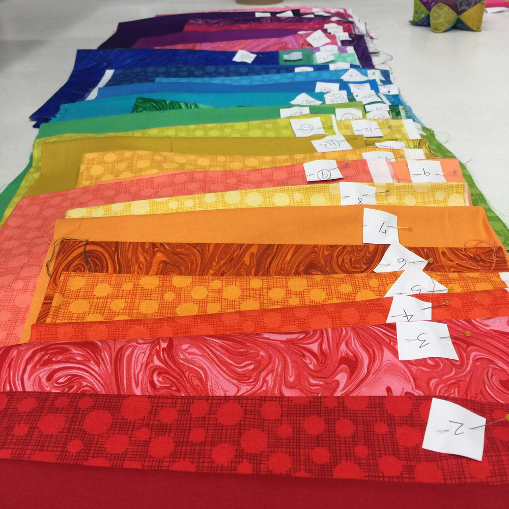 A table with many different colored fabrics on it