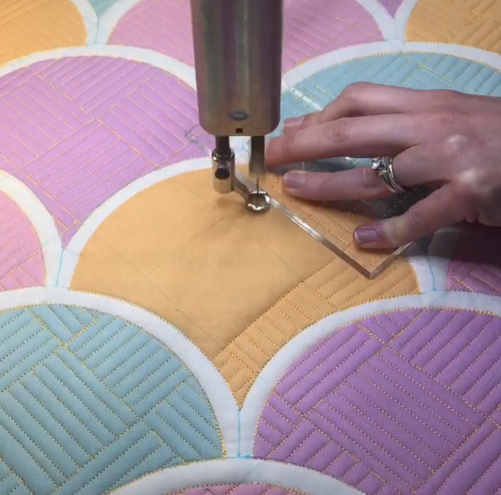 A person using a sewing machine to make quilt.