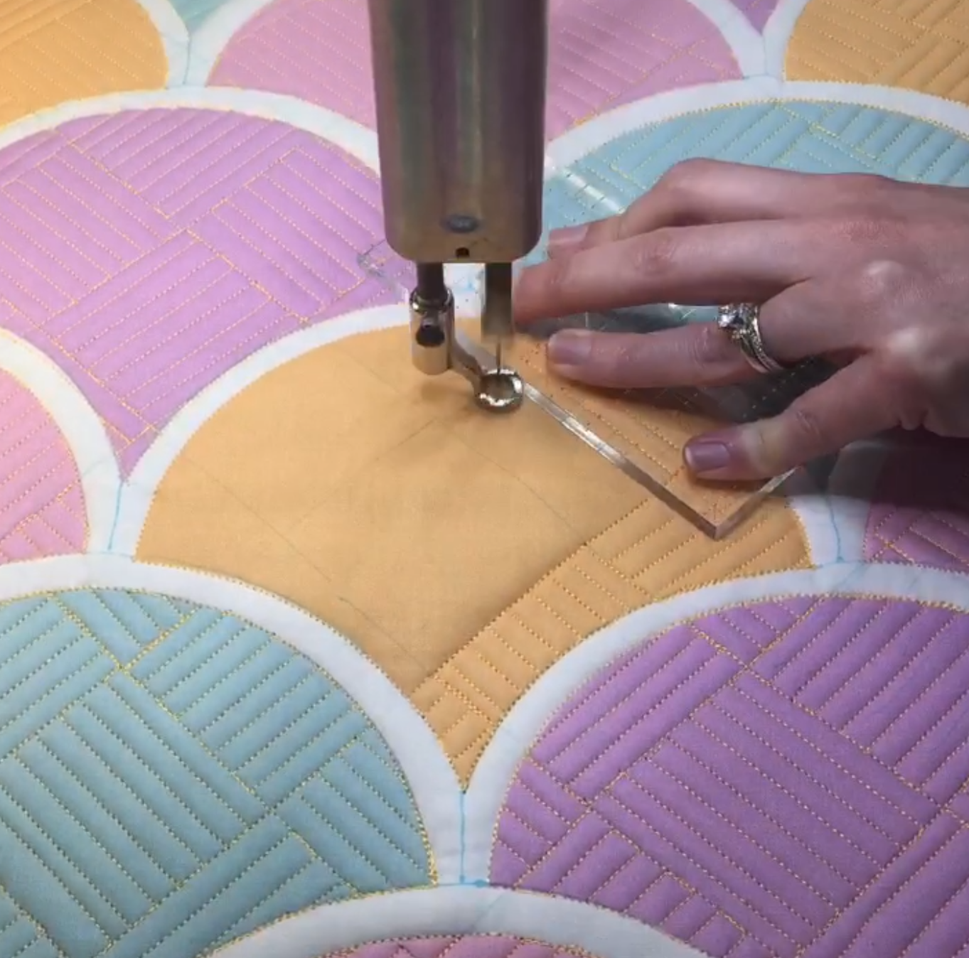 A person using a sewing machine to make quilt.