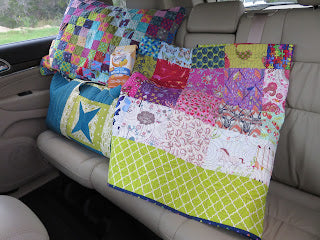 Colorful patchwork pillows and quilts on backseat