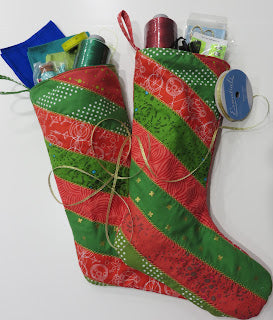 Two red and green Christmas stockings with crafts