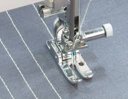 A sewing machine is shown with the foot attached to it.