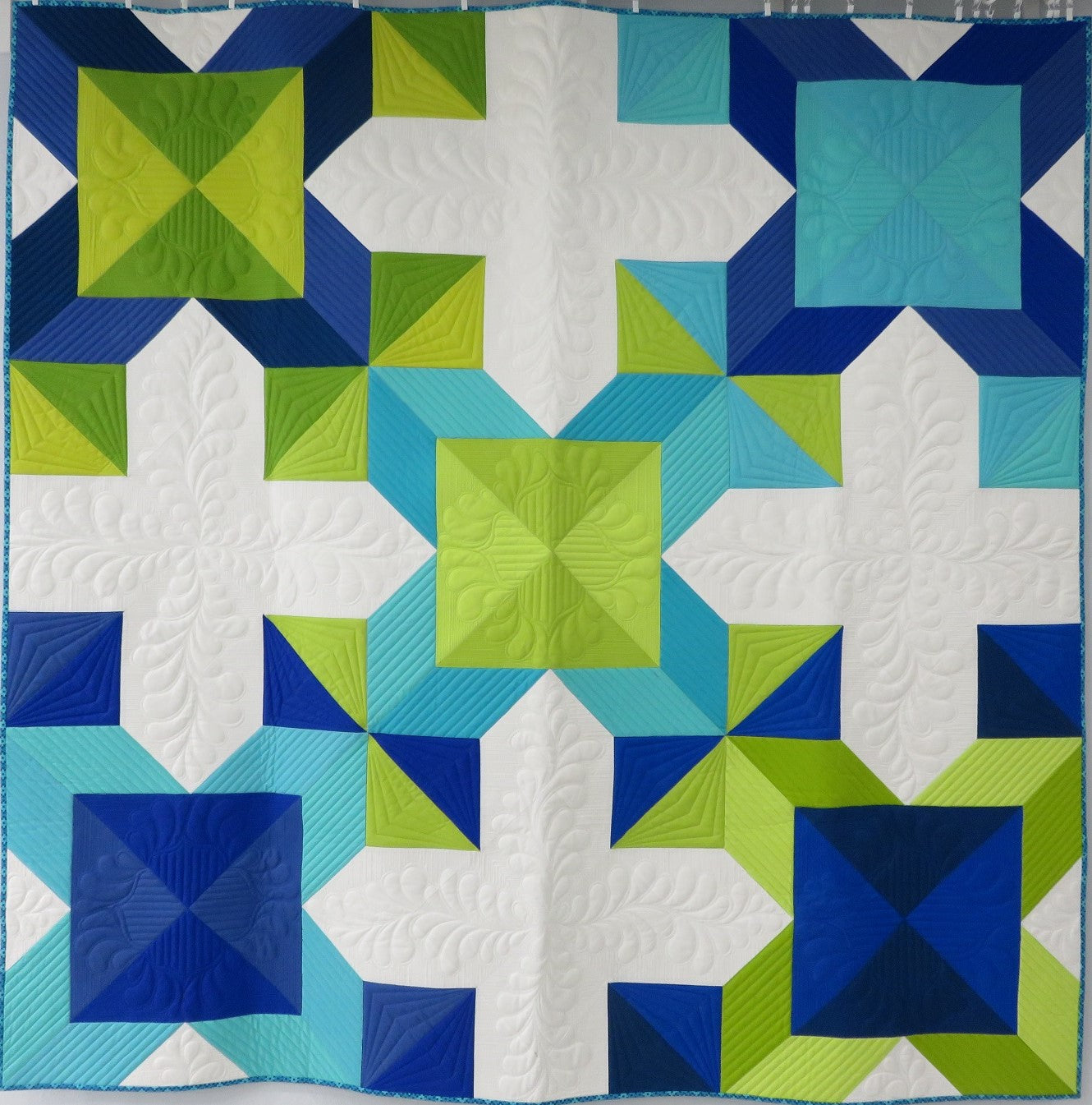 A quilt with different colored squares and shapes.