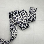 A black and white leopard print ribbon on a table.