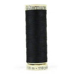 A spool of black thread is sitting on the floor.