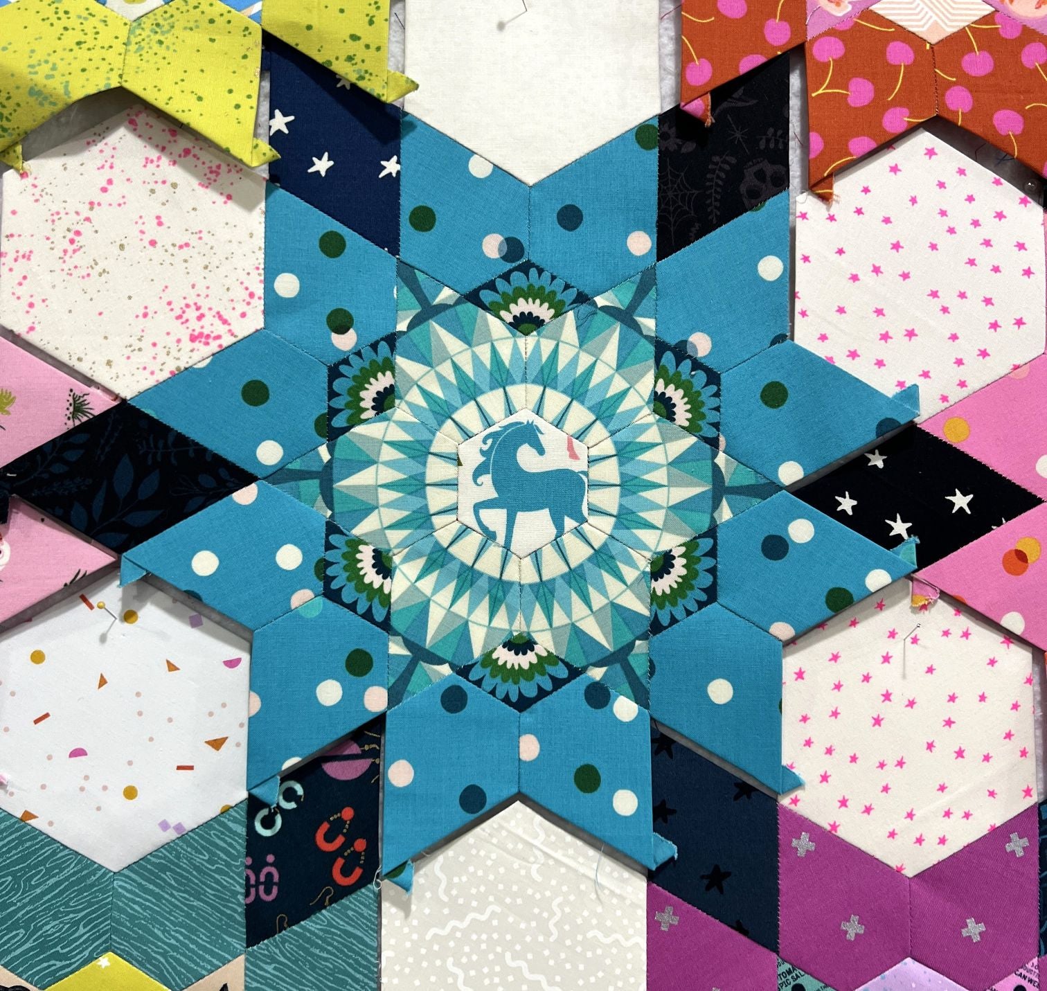 Colorful geometric quilt pattern with star and flower motifs.