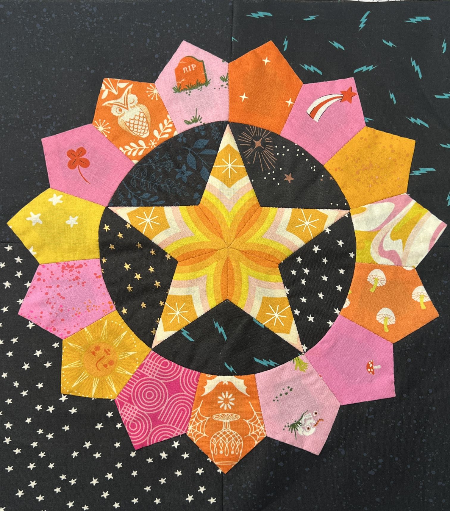 Colorful quilt block featuring a central star and petal shapes.