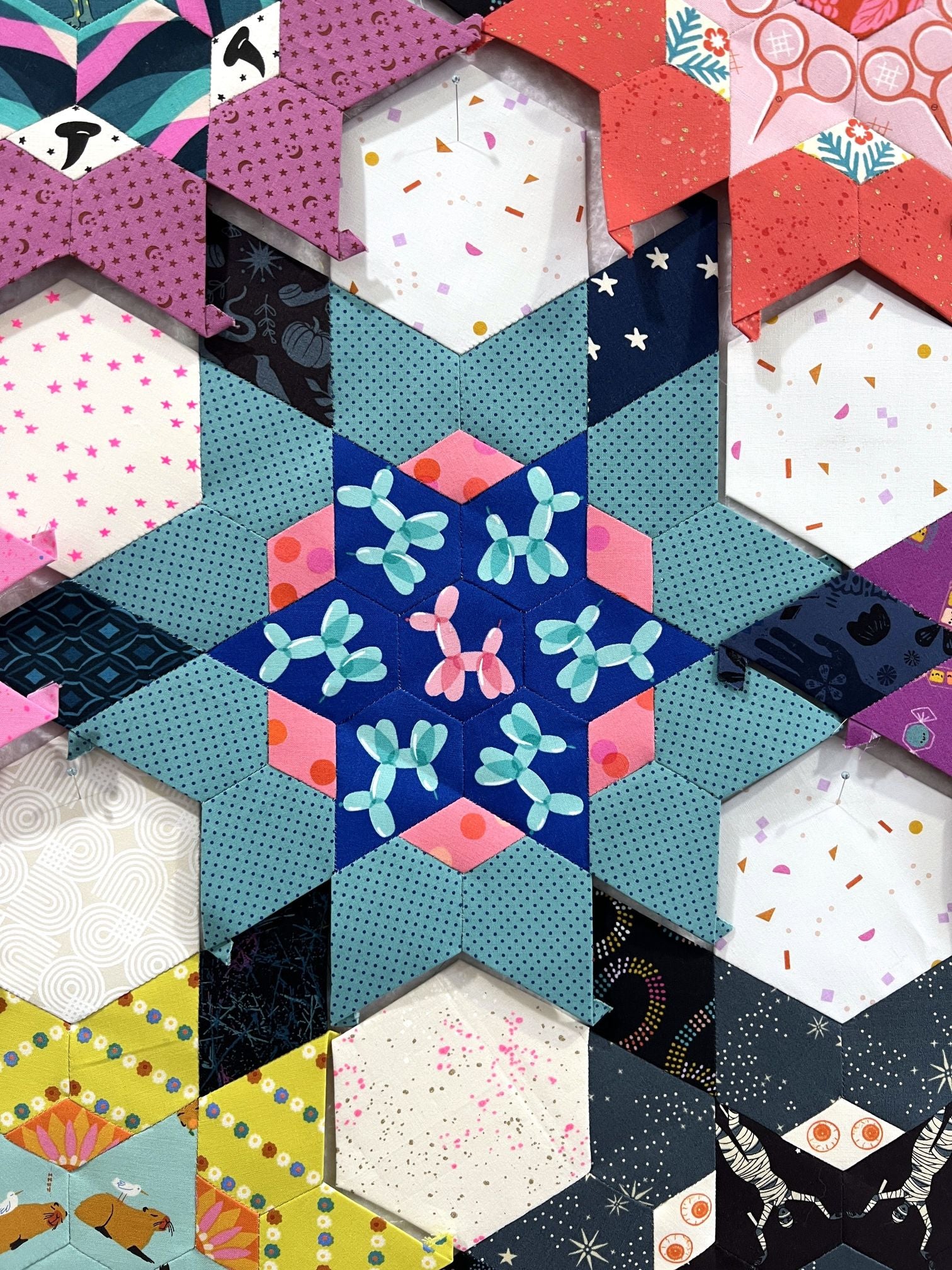 Colorful star quilt pattern made of hexagonal fabric pieces.
