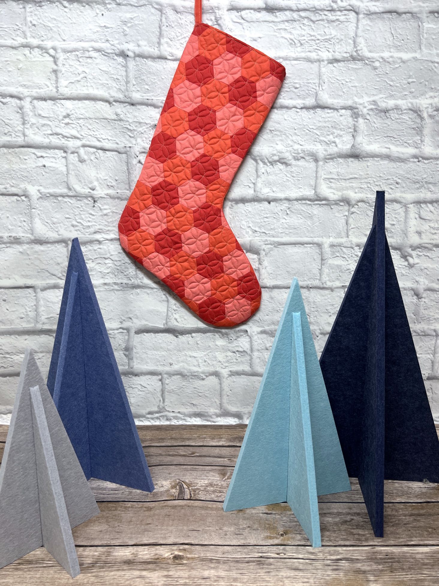 A red stocking hanging on the wall next to paper cones.