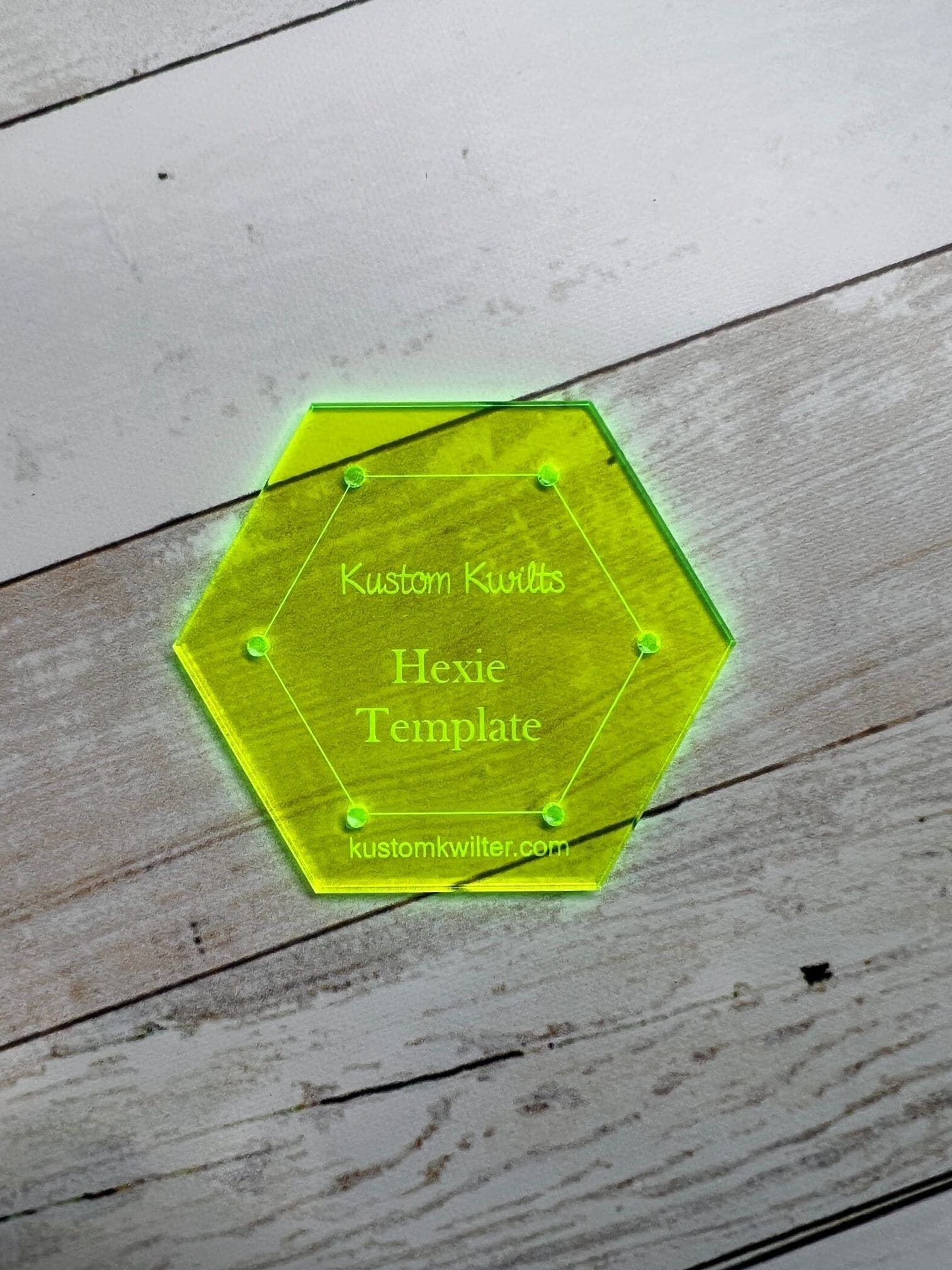 A hexagonal shaped glass coaster with the name of the person.