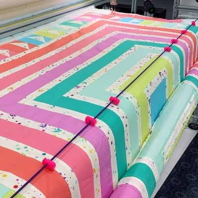 A colorful quilt being made on the machine.