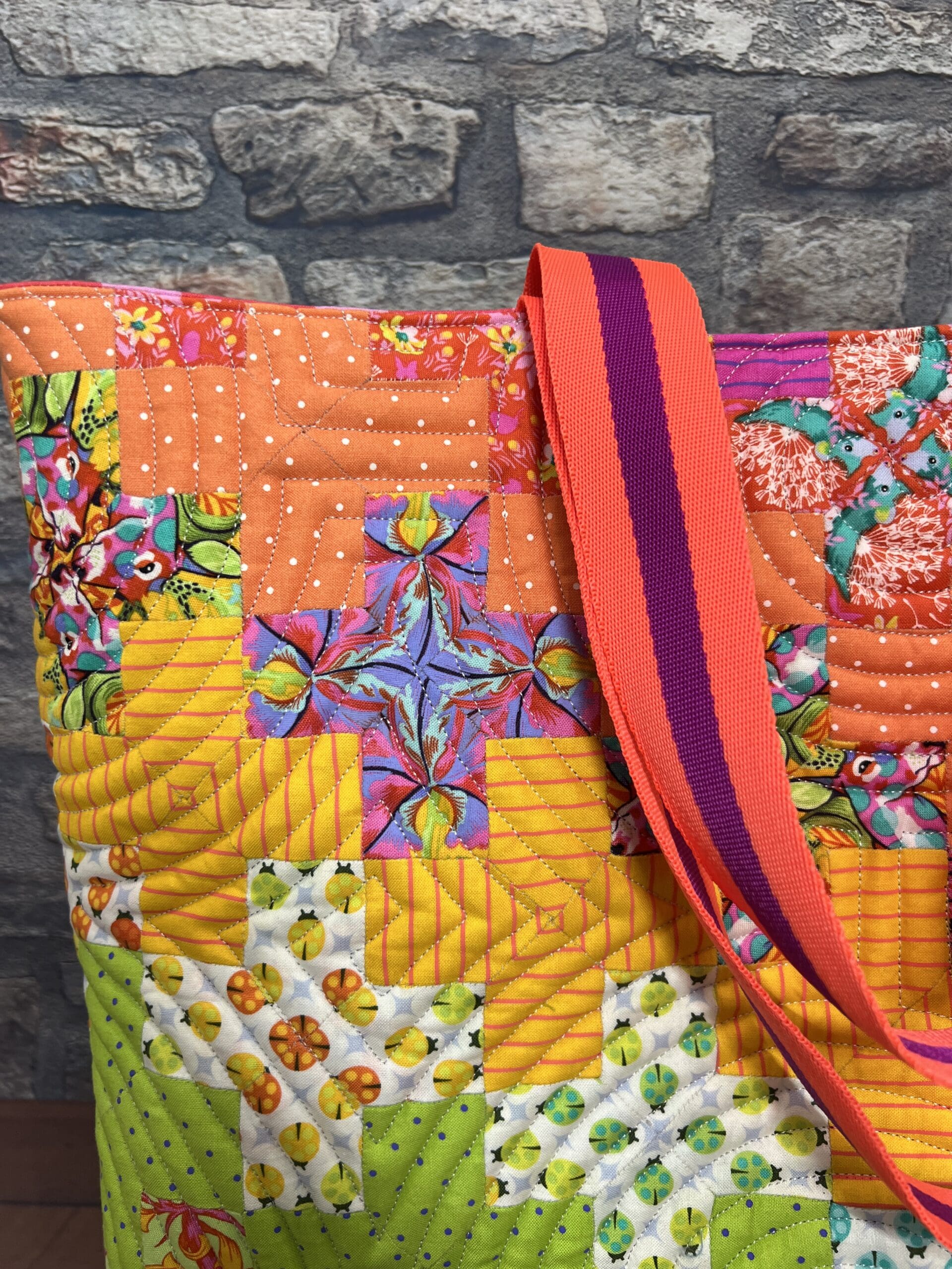 A close up of the shoulder strap on a quilted bag
