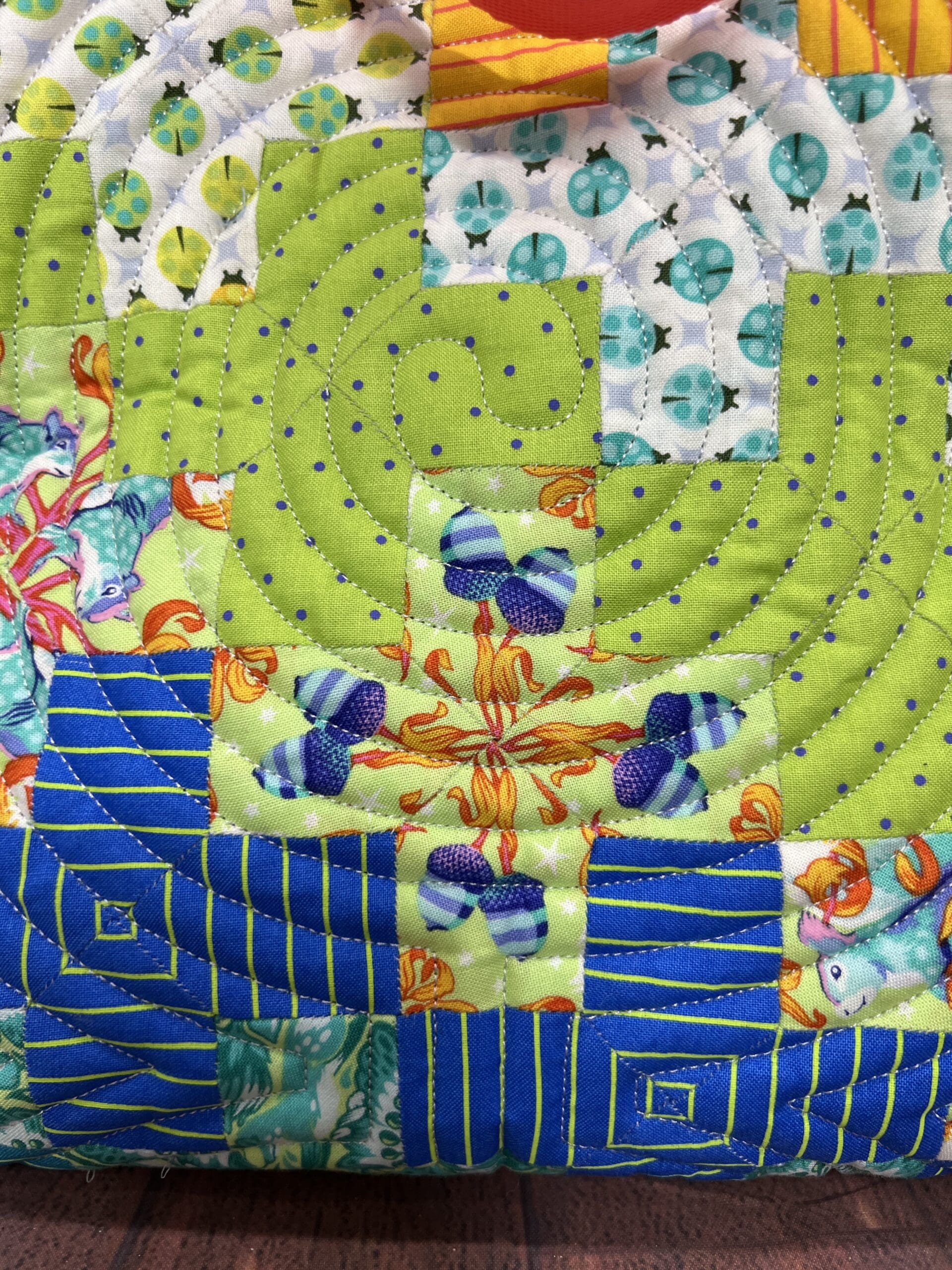 A close up of the quilt with blue and green designs
