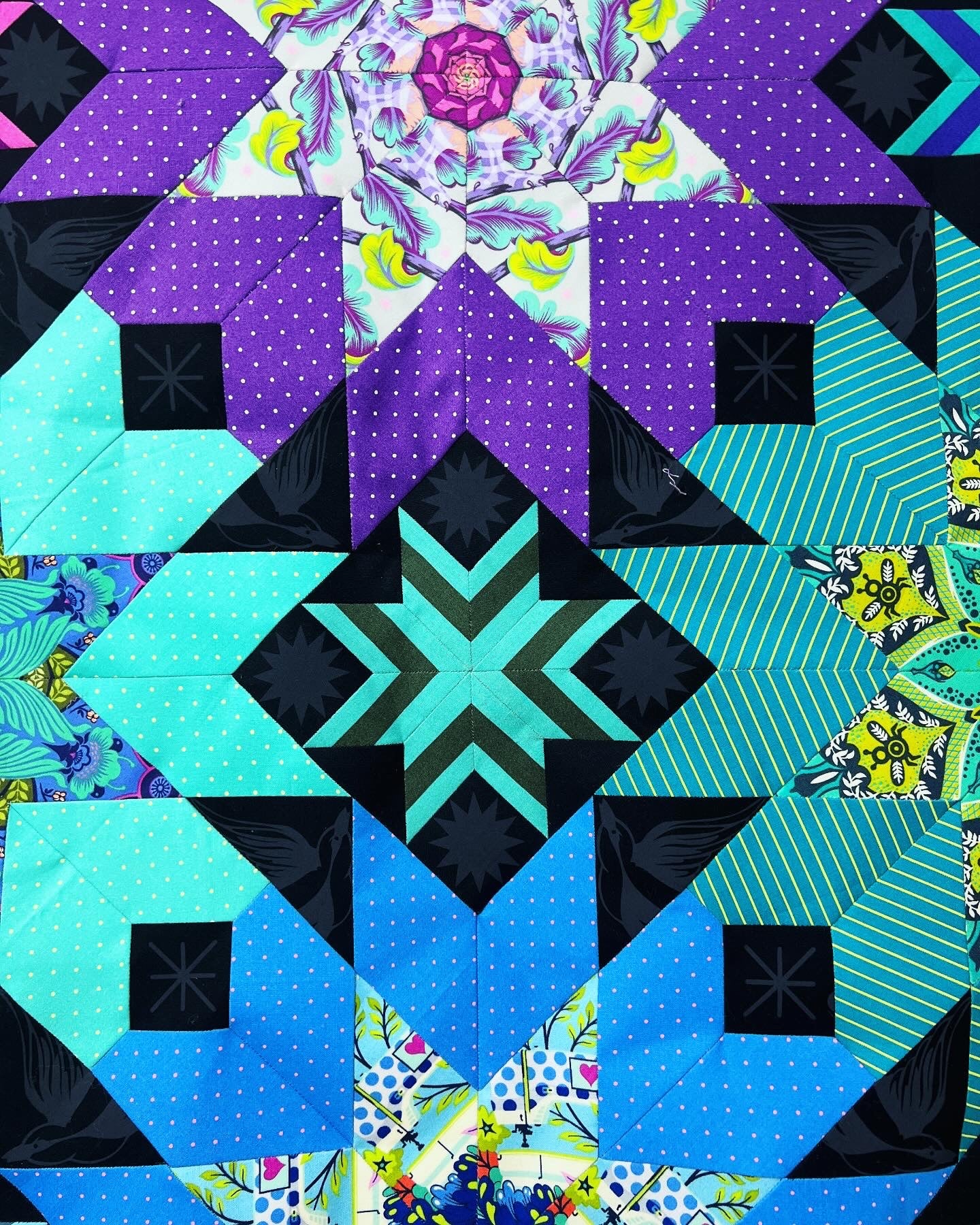 A quilt with different colored squares and designs.