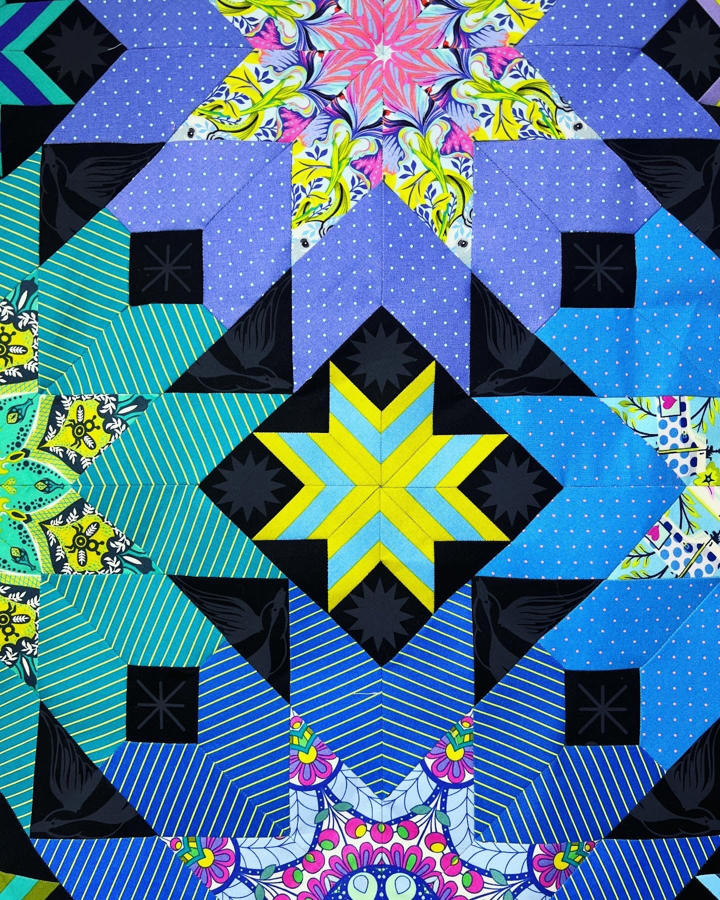A quilt with blue and yellow designs on it.