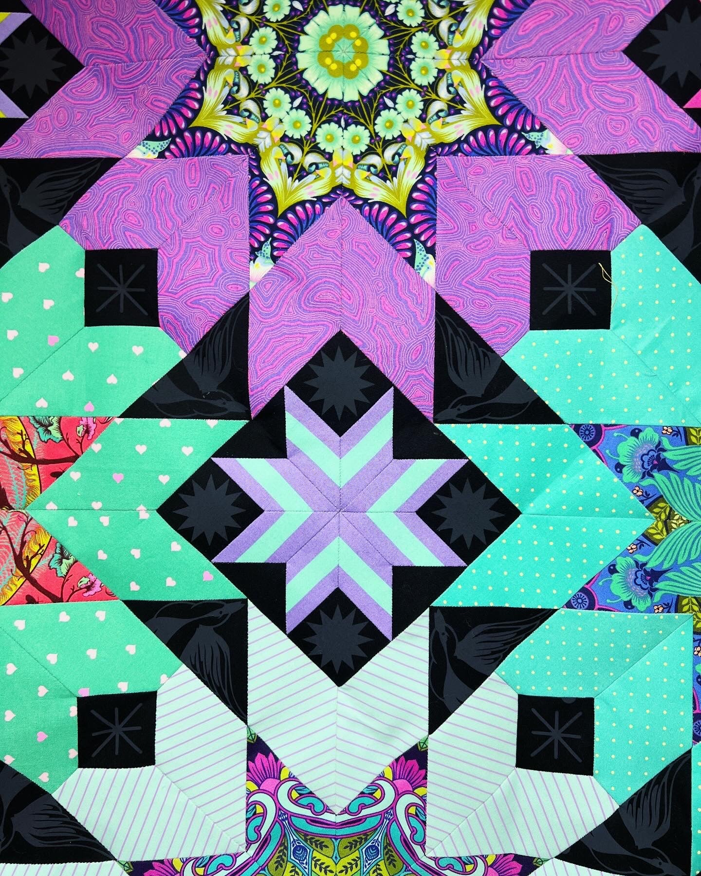 A quilt with different colored designs on it.