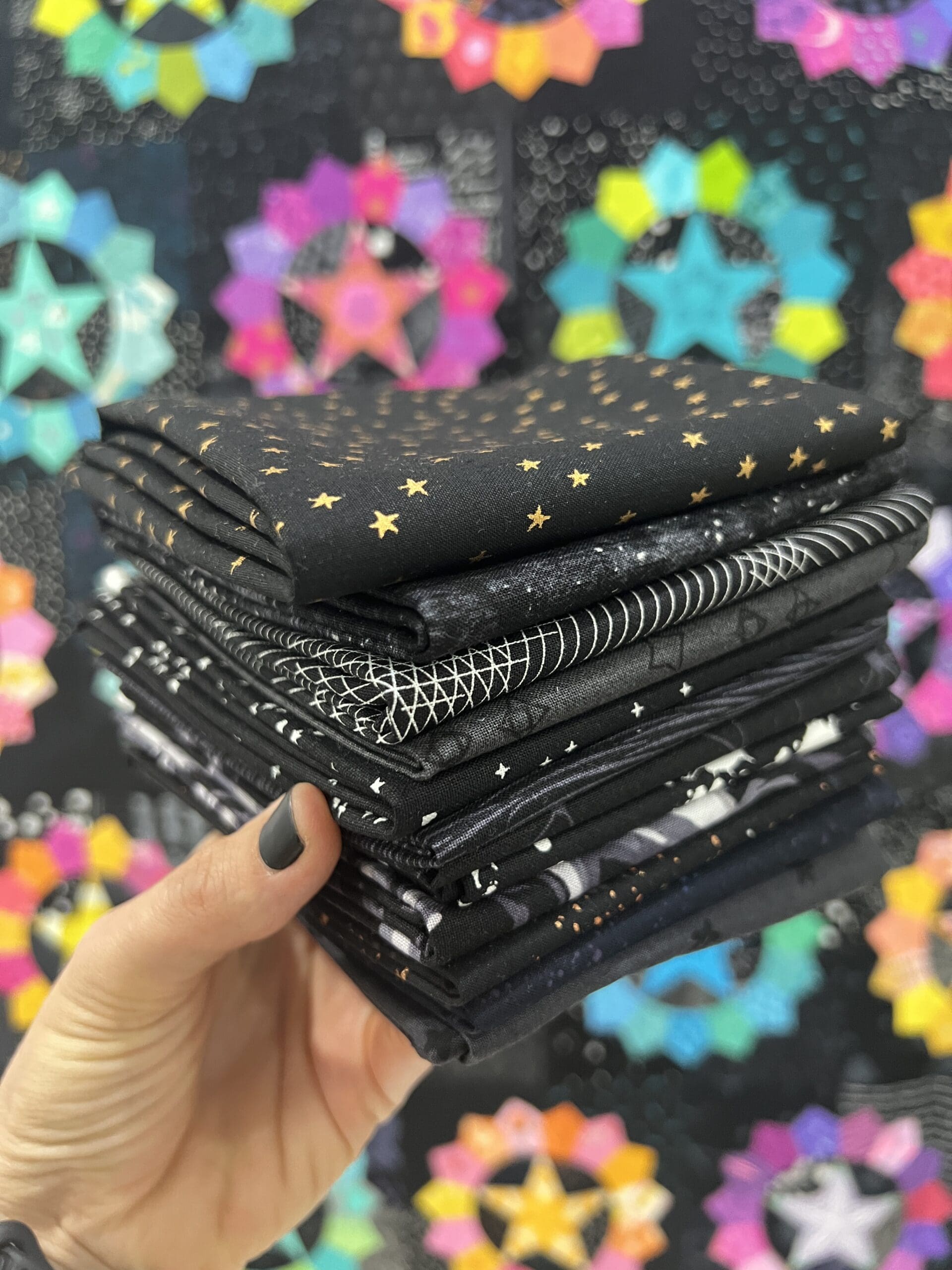 A stack of black fabric pieces with star patterns in various sizes.