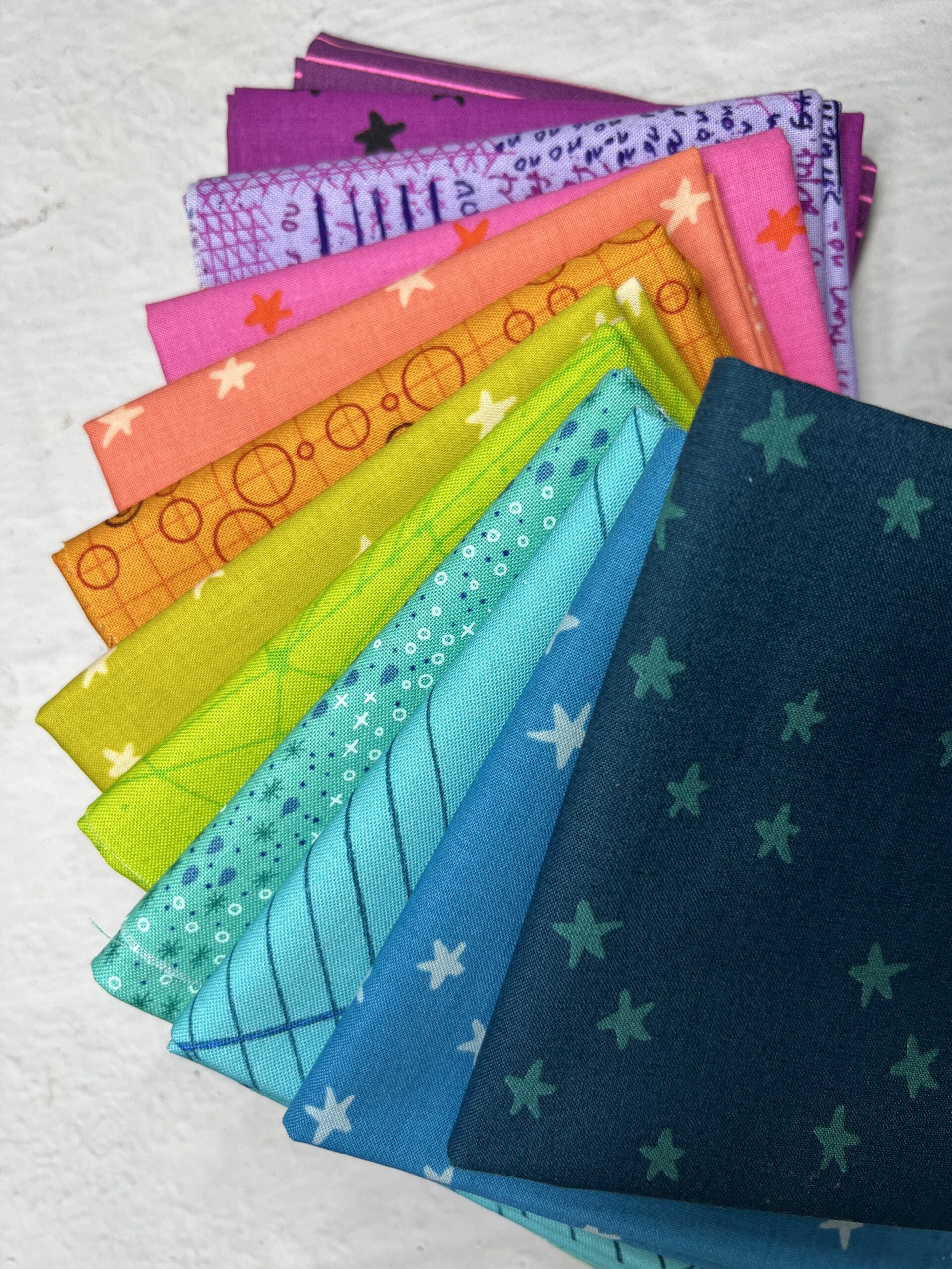 A colorful array of patterned fabric pieces arranged in a fan shape.