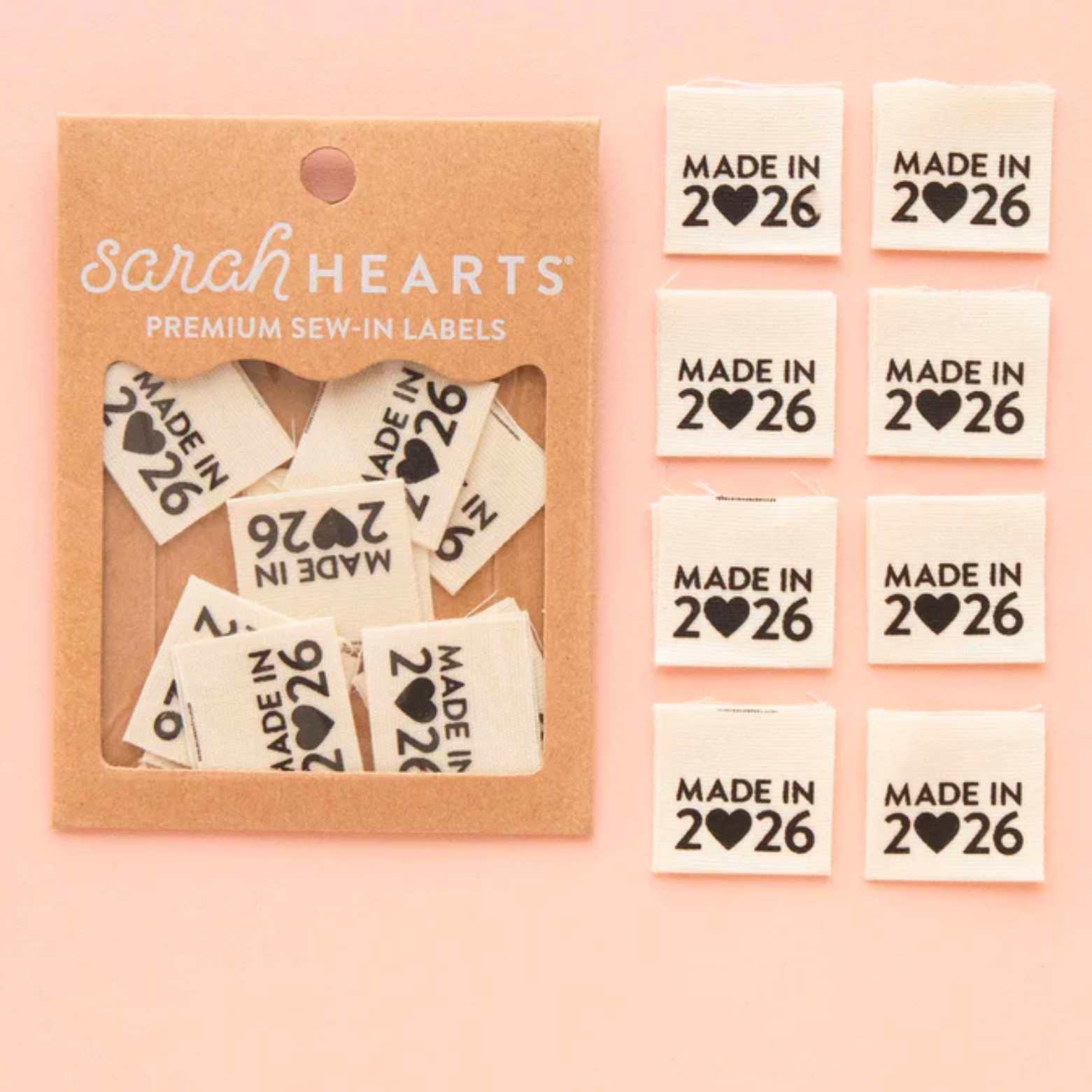Cute heart-shaped pins with "Made in 2026" text and various symbols.