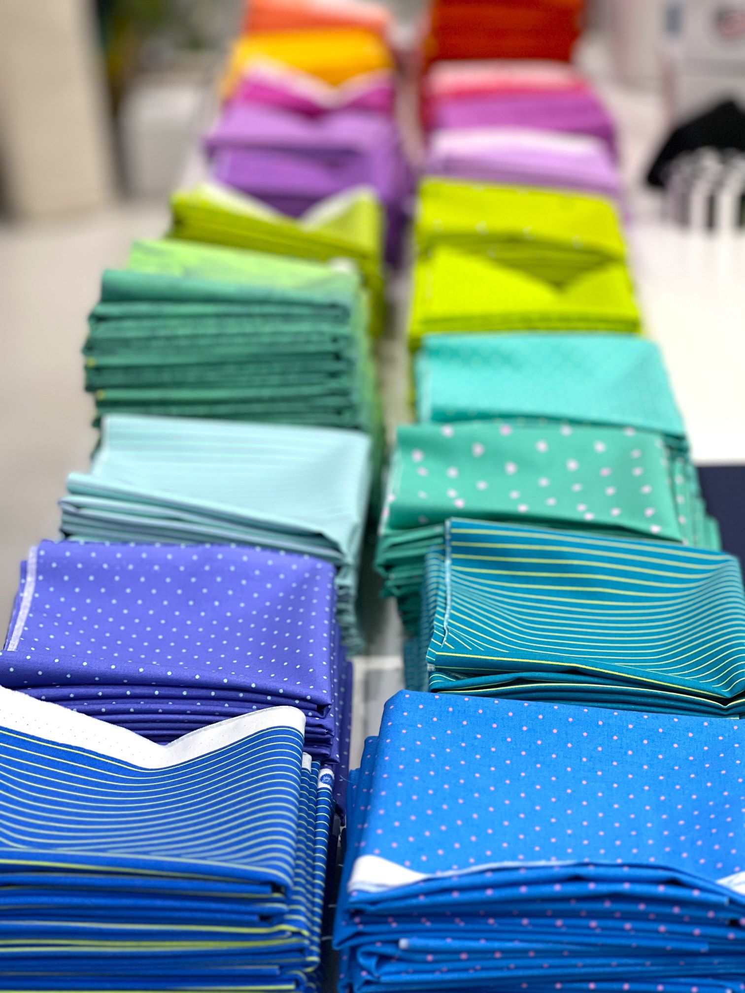 A table with many different colored cloth napkins.