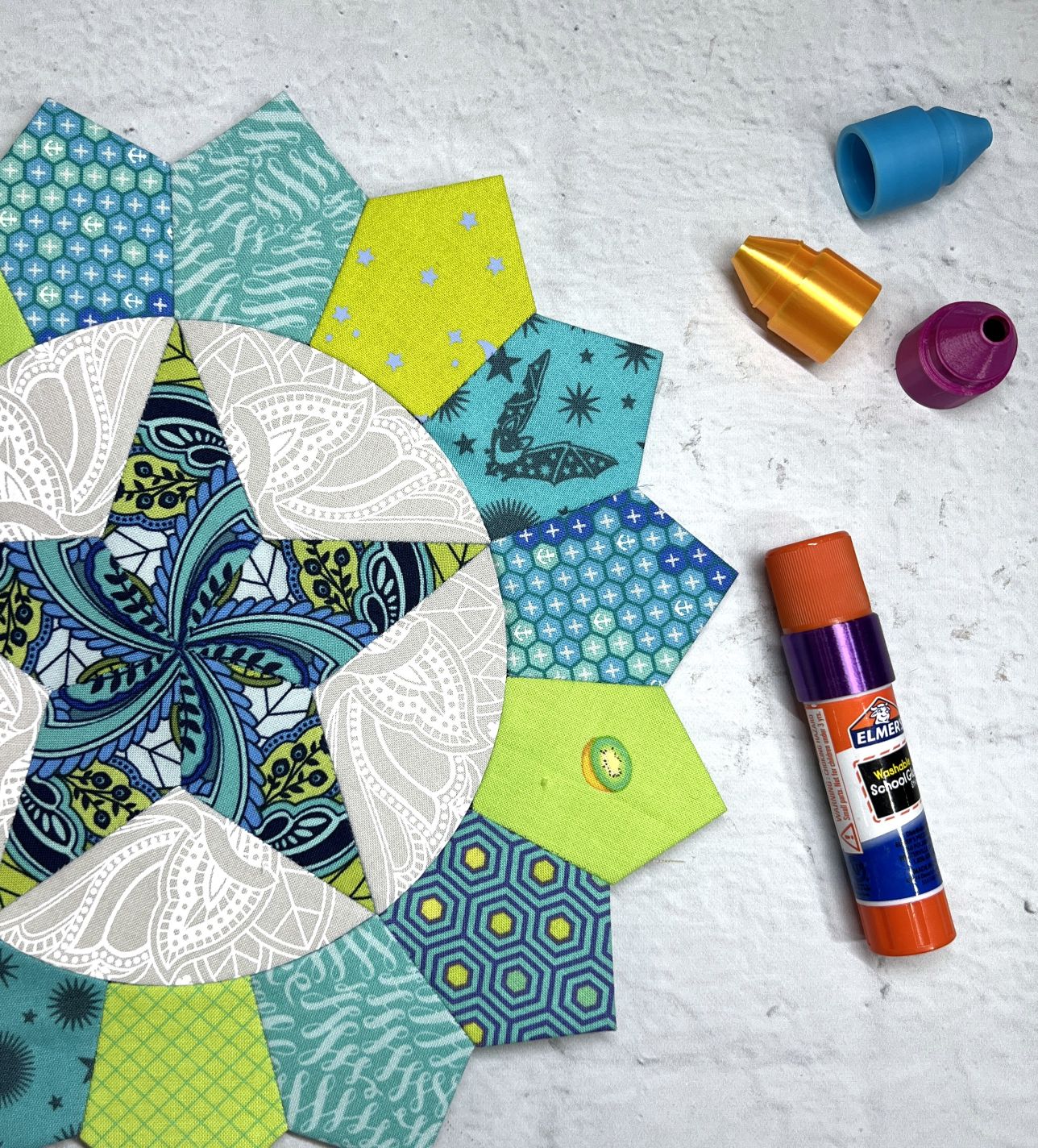 Colorful paper shapes and a glue stick for crafting.