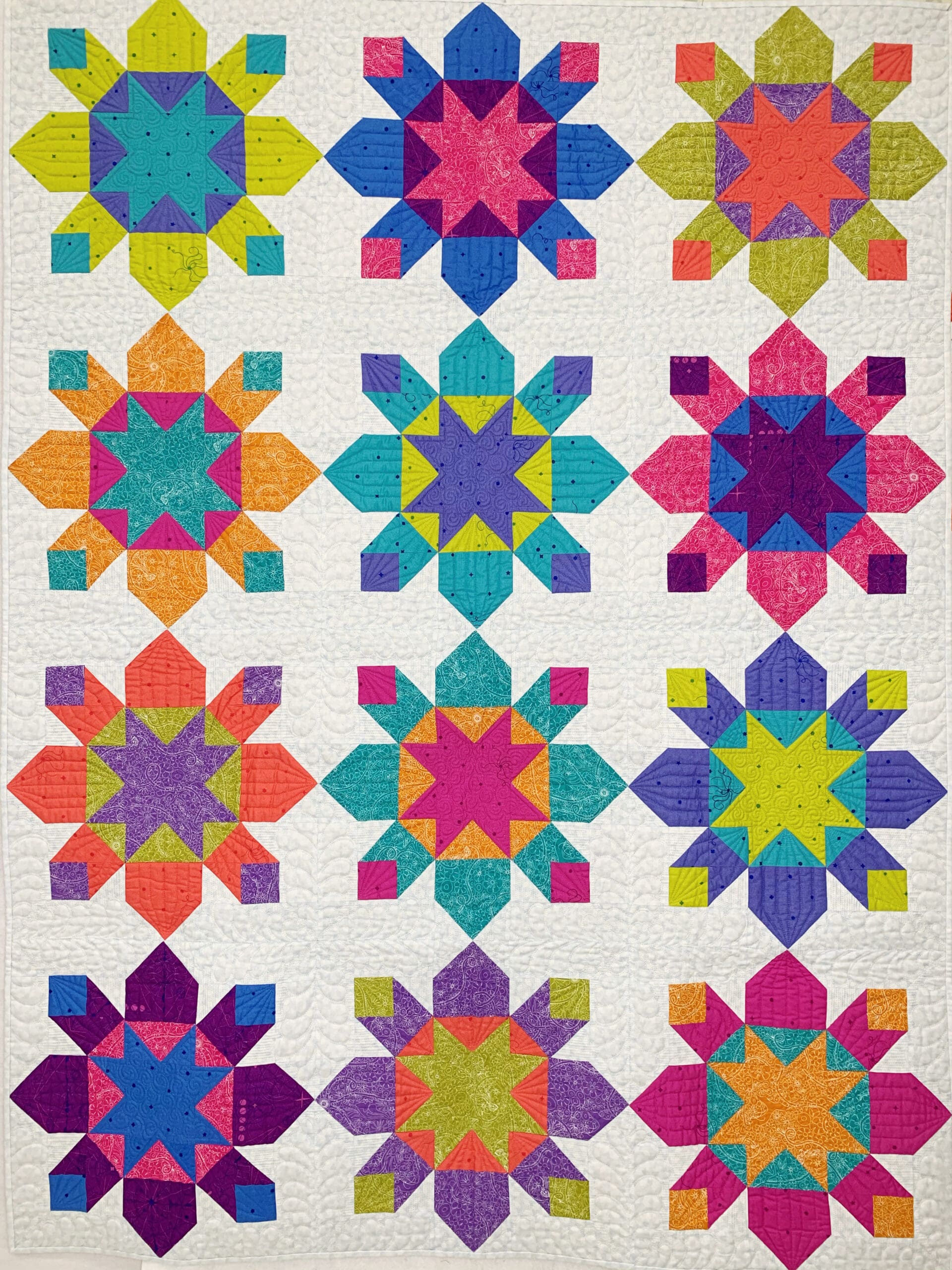 A quilt with different colored stars on it.