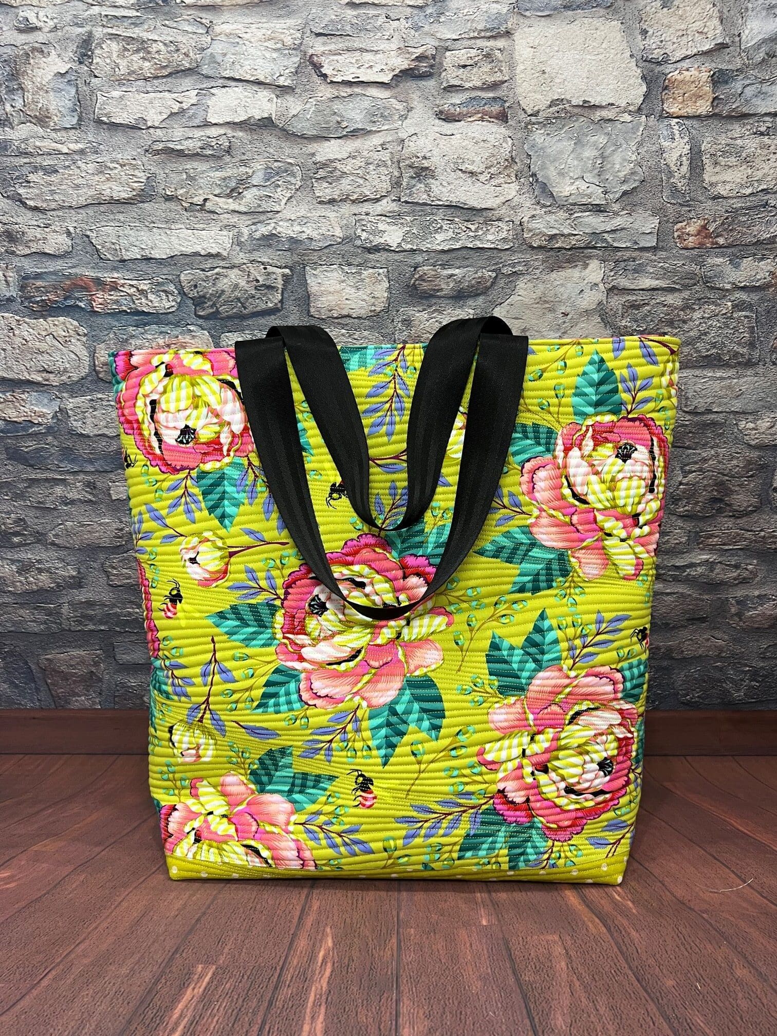A yellow bag with pink flowers on it
