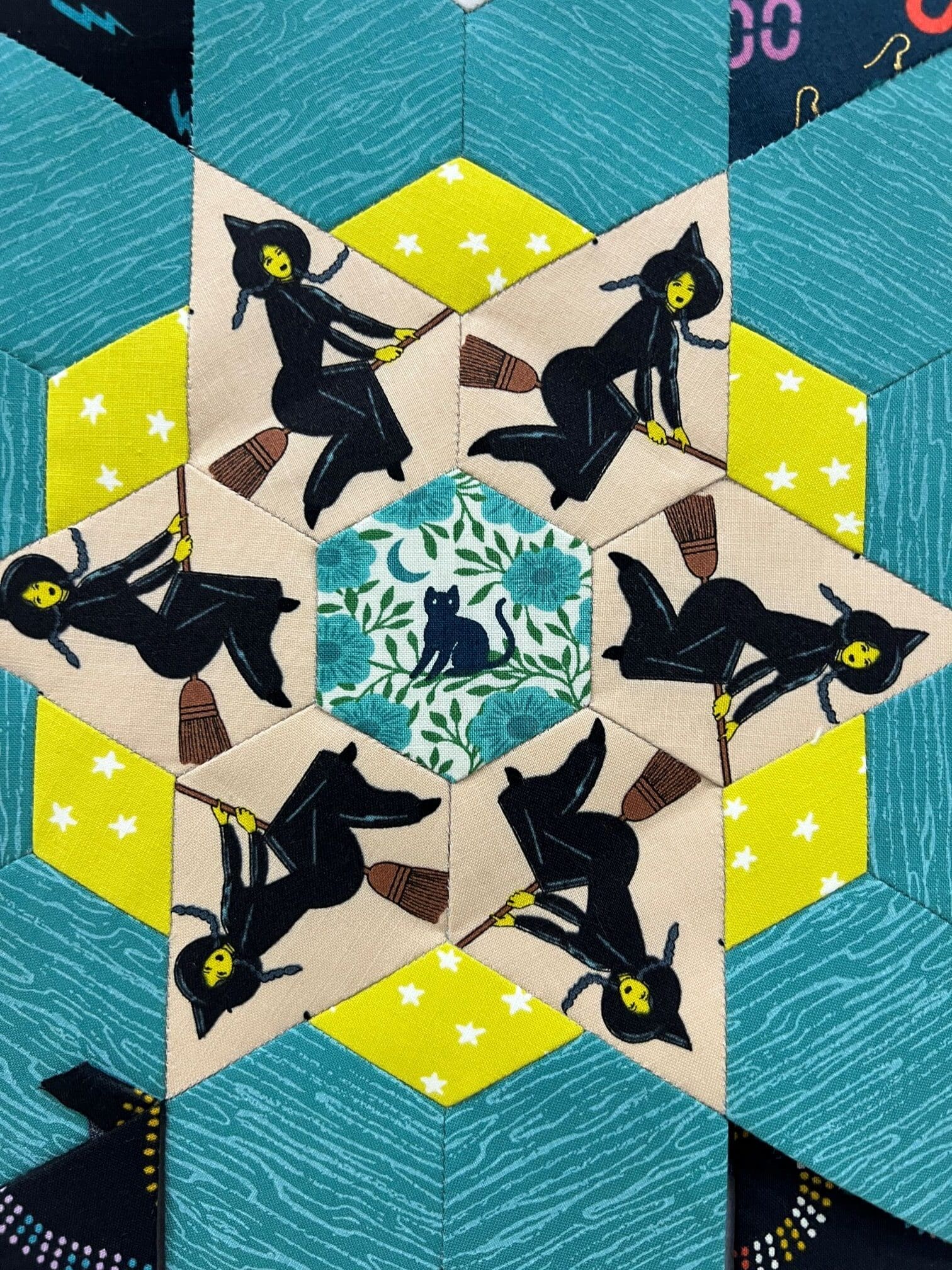 Geometric art with silhouetted dancers around a central floral design.