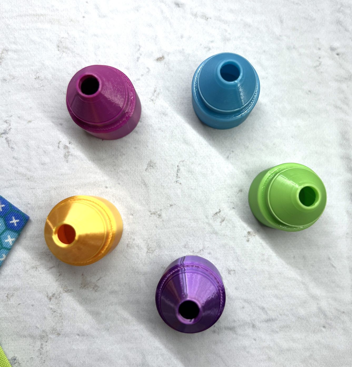Colorful plastic beads scattered on a white textured surface.