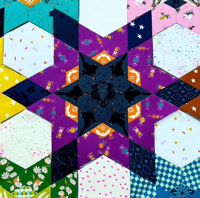 A vibrant geometric star pattern with various colorful textures.