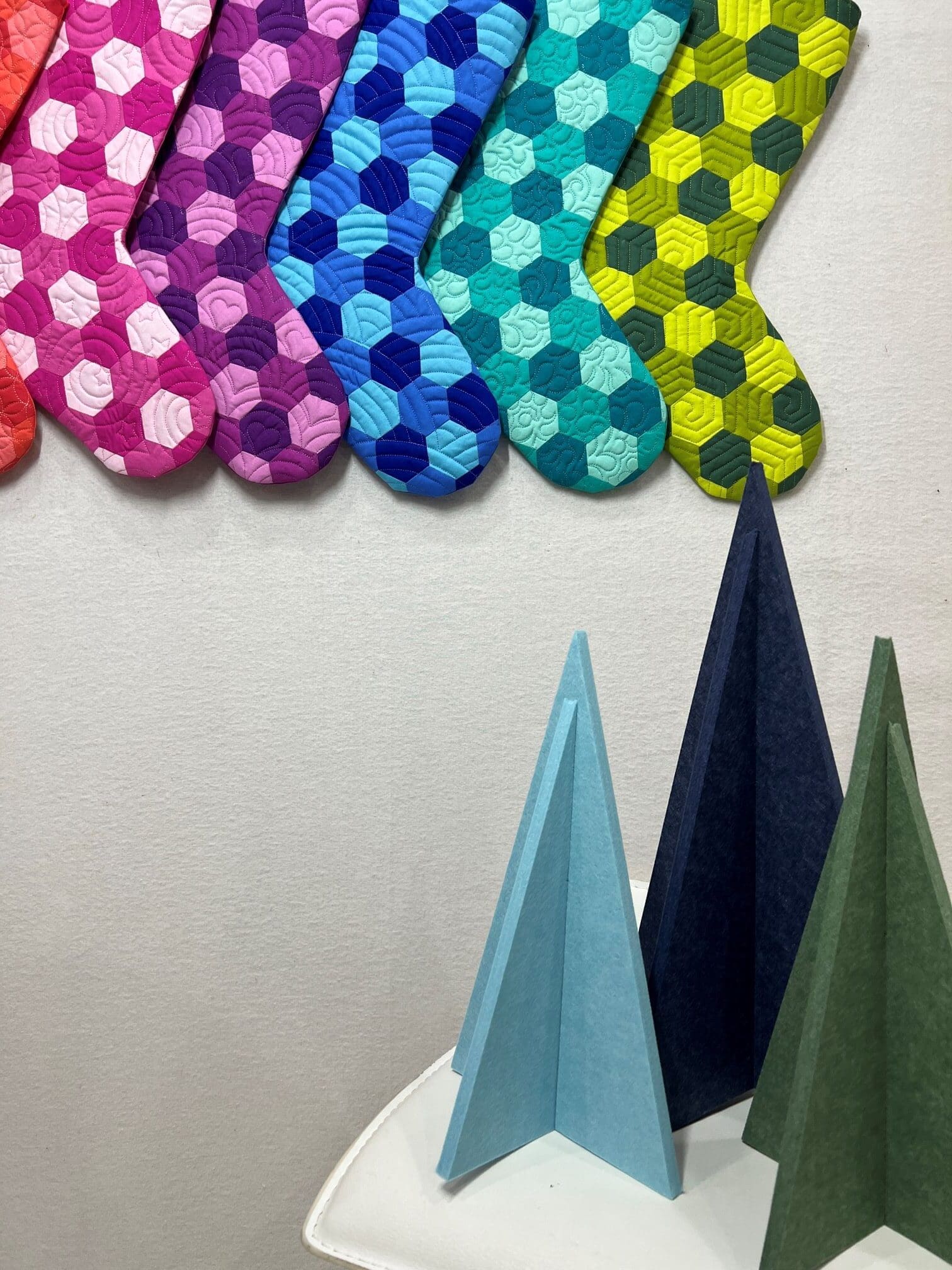 A wall with many different colored socks hanging on it.