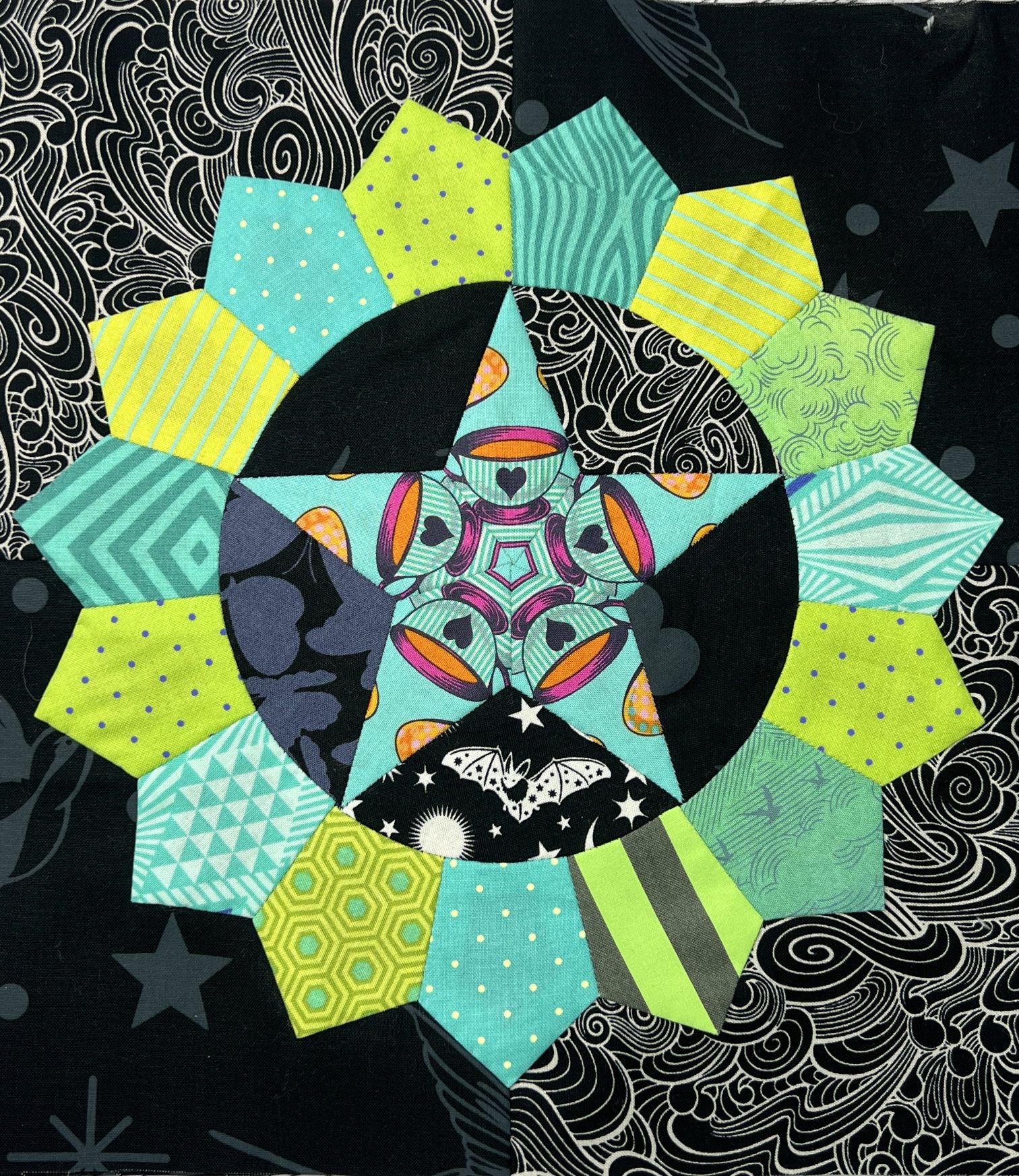 Colorful geometric star quilt block on patterned fabric.