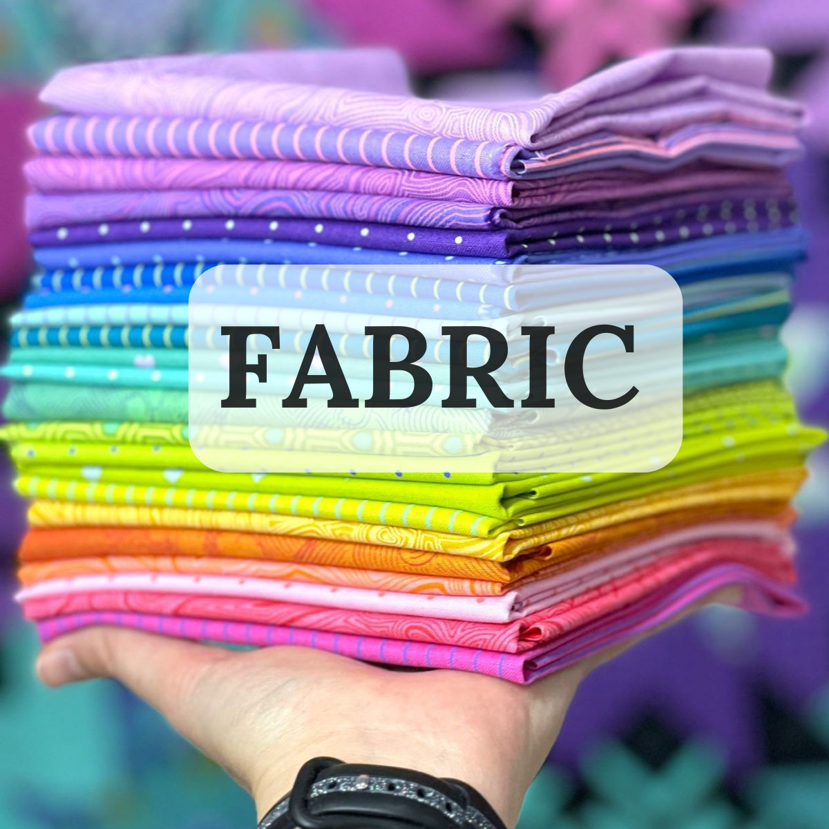 Hand holding up bundles of colorful fabric