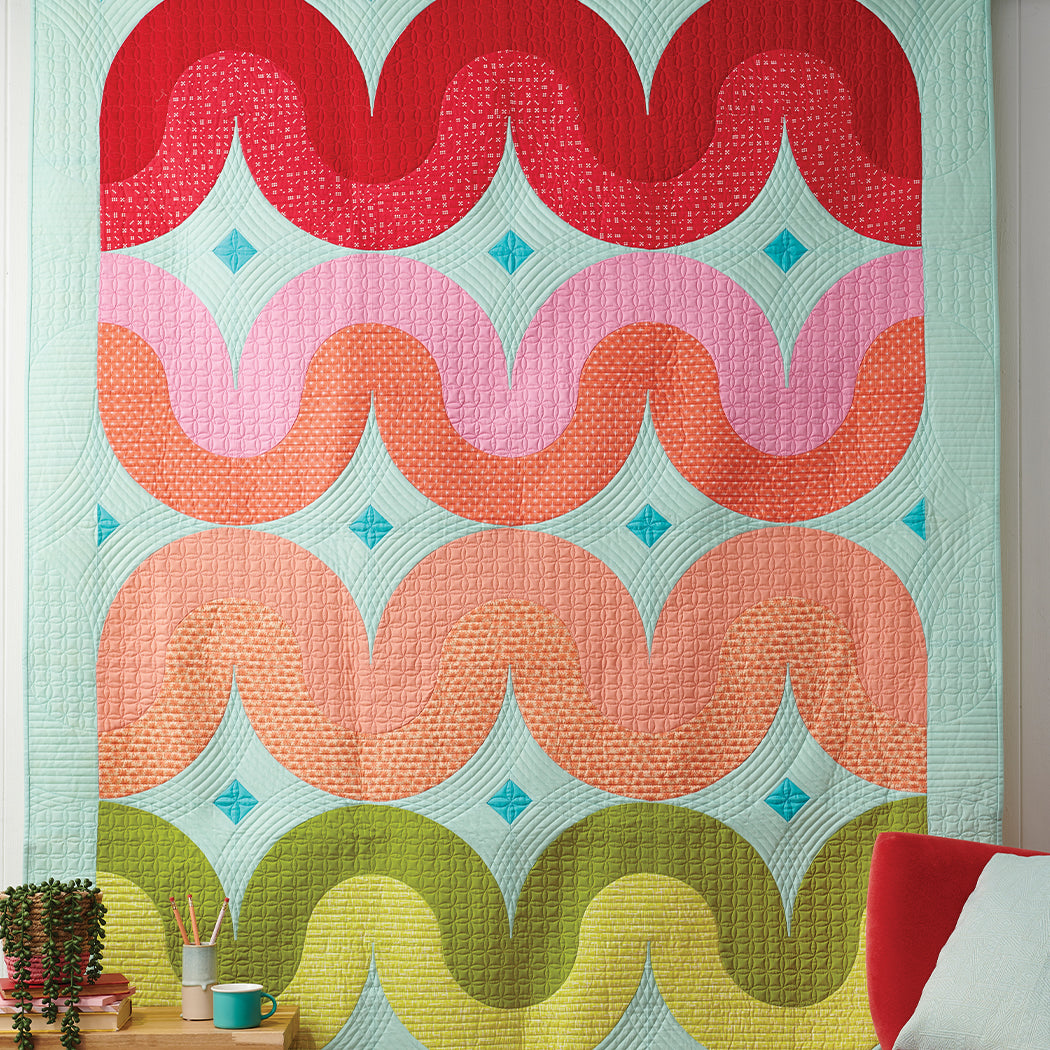 A quilt hanging on the wall in a room.