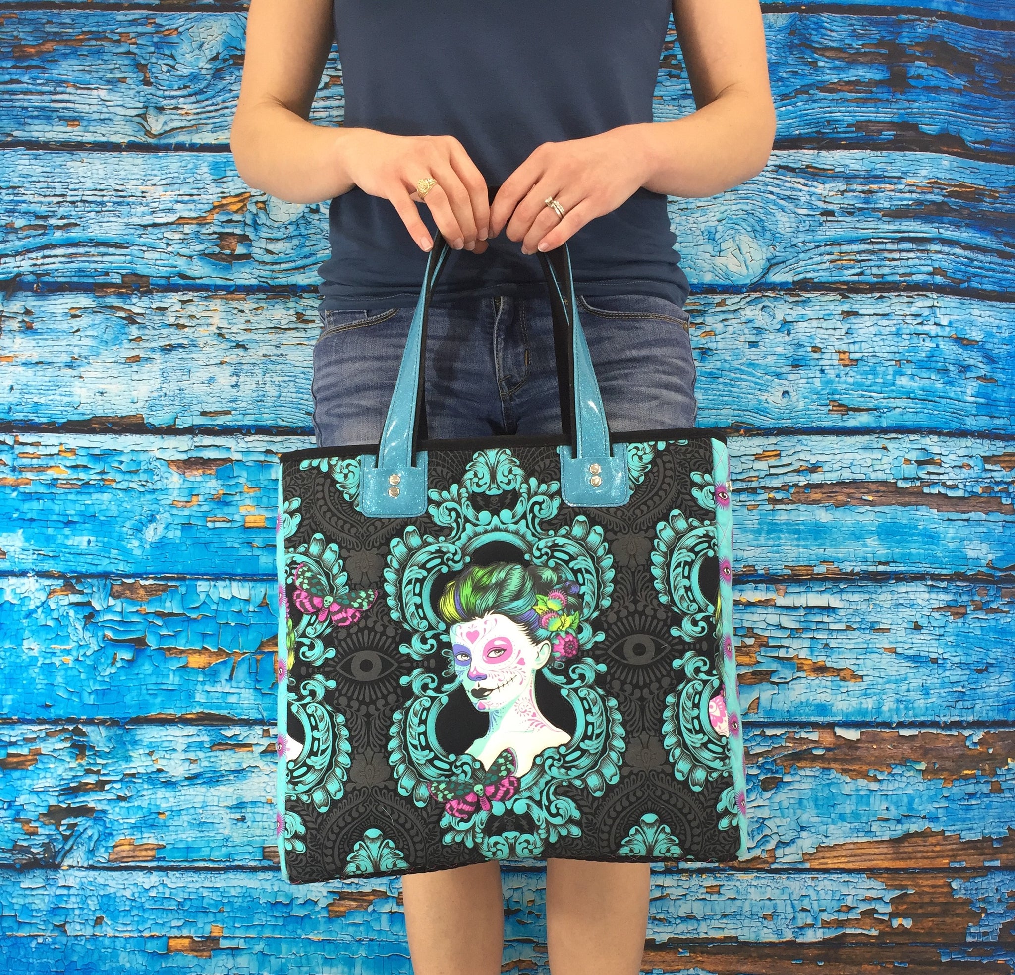 A woman holding onto a bag with a picture of frida kahlo on it