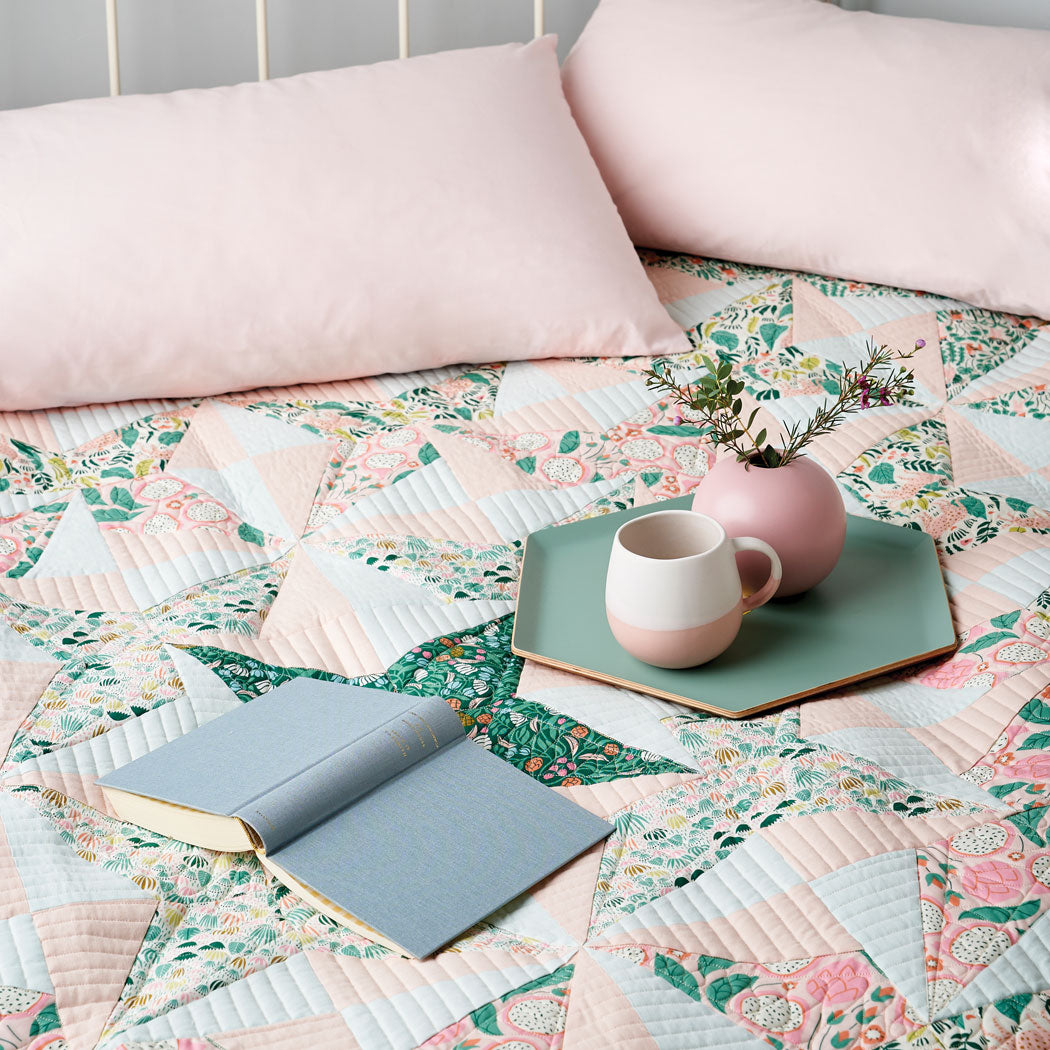 A bed with a quilt and pillow on it