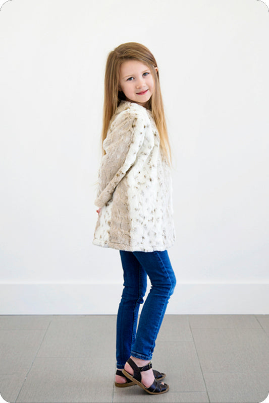A little girl standing in front of the wall