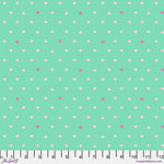 A green background with white and pink polka dots.