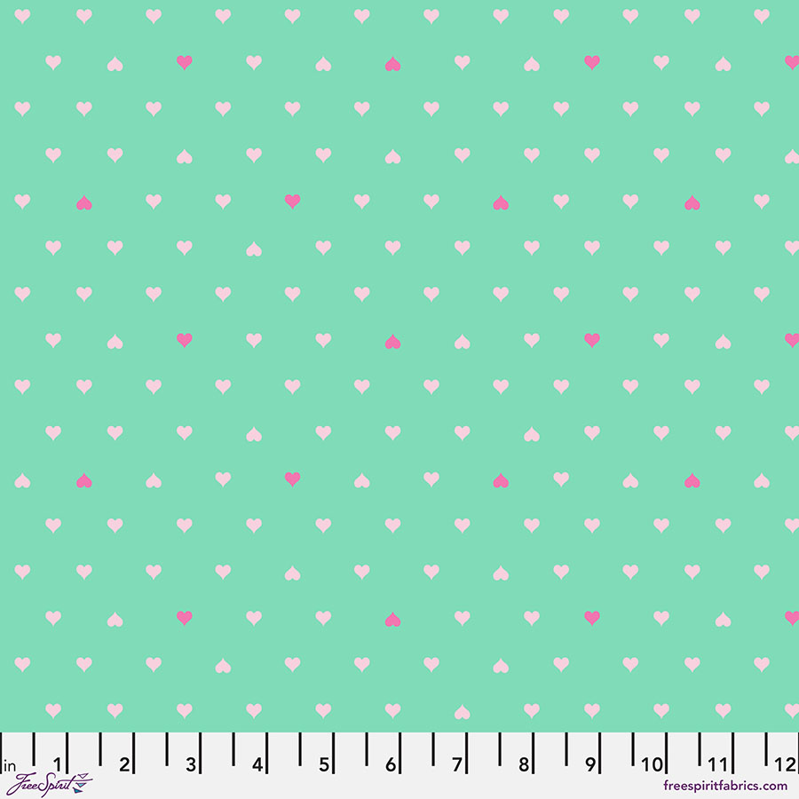 A green background with white and pink polka dots.