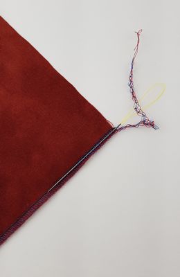 A red piece of fabric with a string hanging from it.