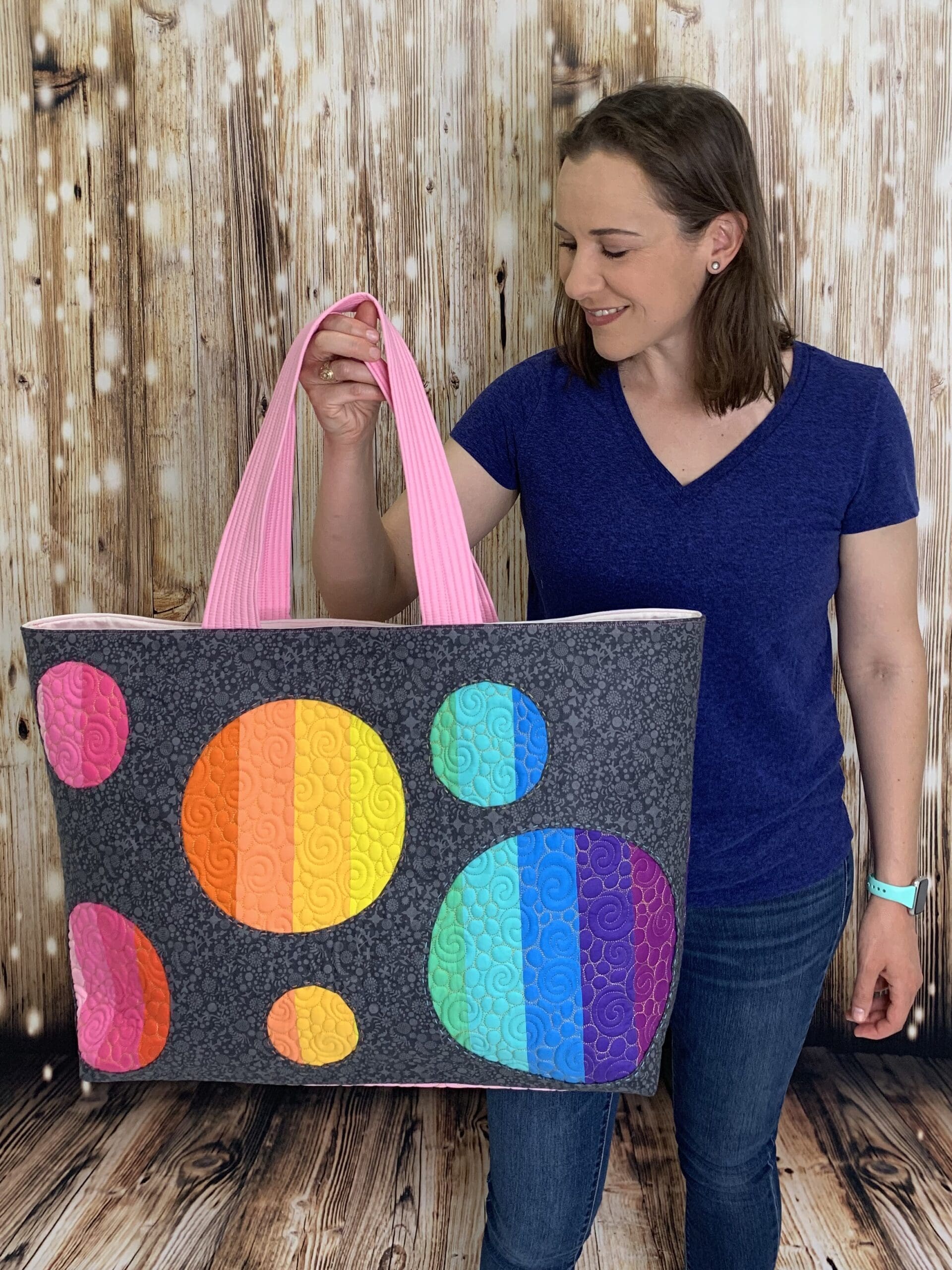 A woman holding onto a large bag with colorful circles on it