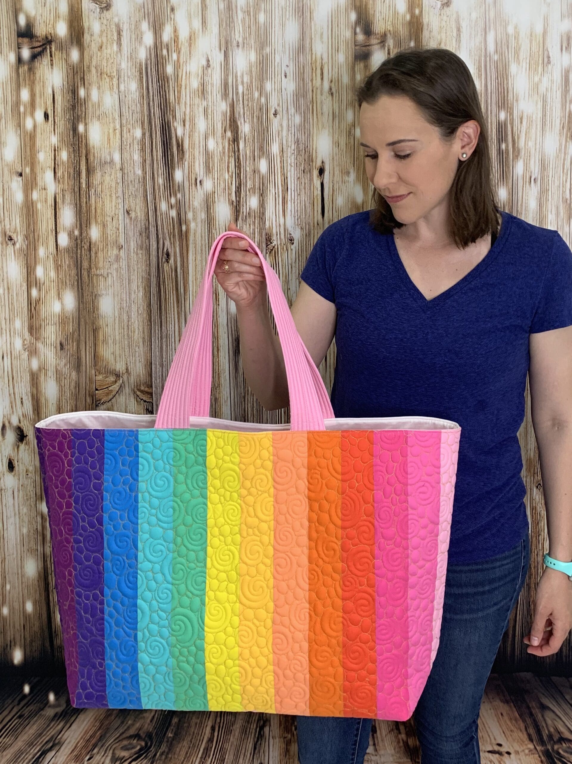 A woman holding onto a large rainbow bag