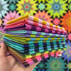 A stack of folded paper in front of a colorful background.