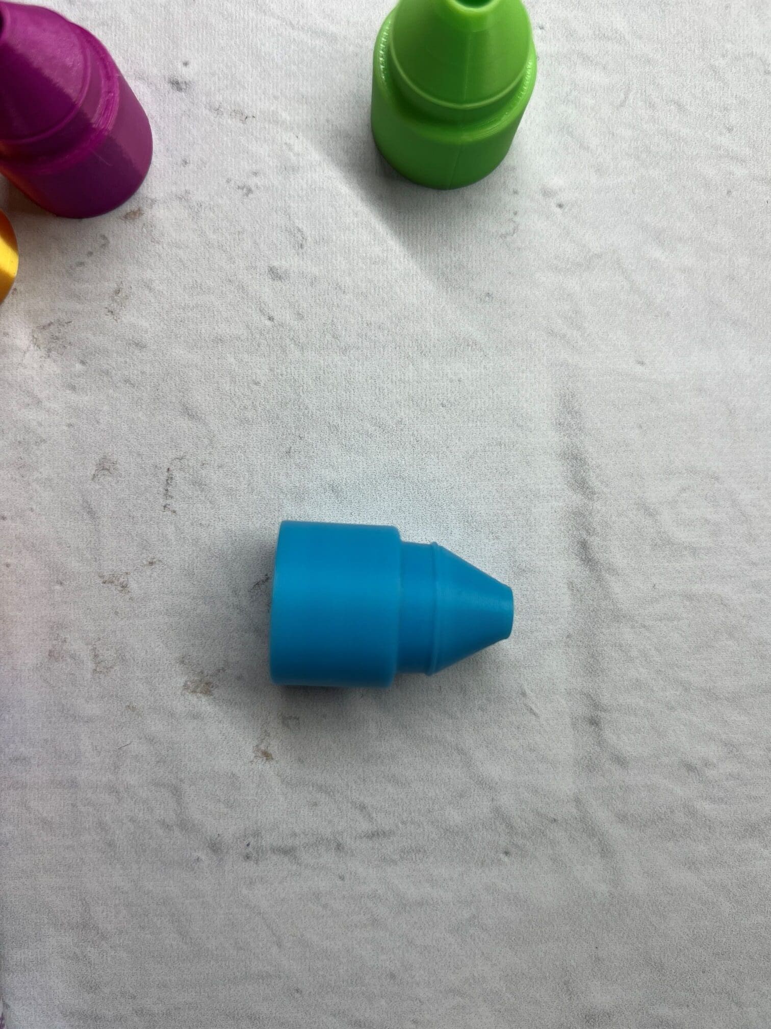 A small blue LEGO piece on a white surface.
