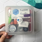 A quilting starter kit with essential tools in a clear plastic case.