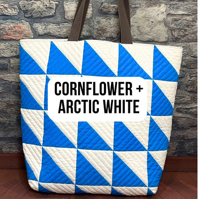 A blue and white bag sitting on top of a brick wall.