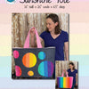 A woman holding onto a large bag with circles on it
